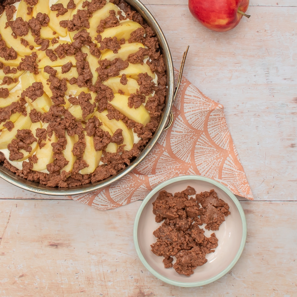 Streusel auf Apfelkuchen verteilen